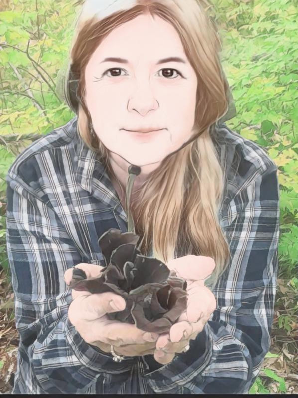 Tess Kenney wearing a bucket hat out in some vibrant green woods holding up a handful of mushrooms. They look like they might be hen-of-the-woods, Grifola frondosa.